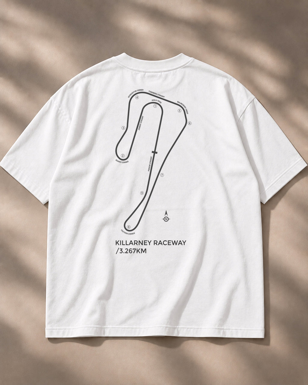 Circuit 001 Detailed tee in white, laid flat from the back: the Killarney Raceway map with every corner numbered and named, printed in black