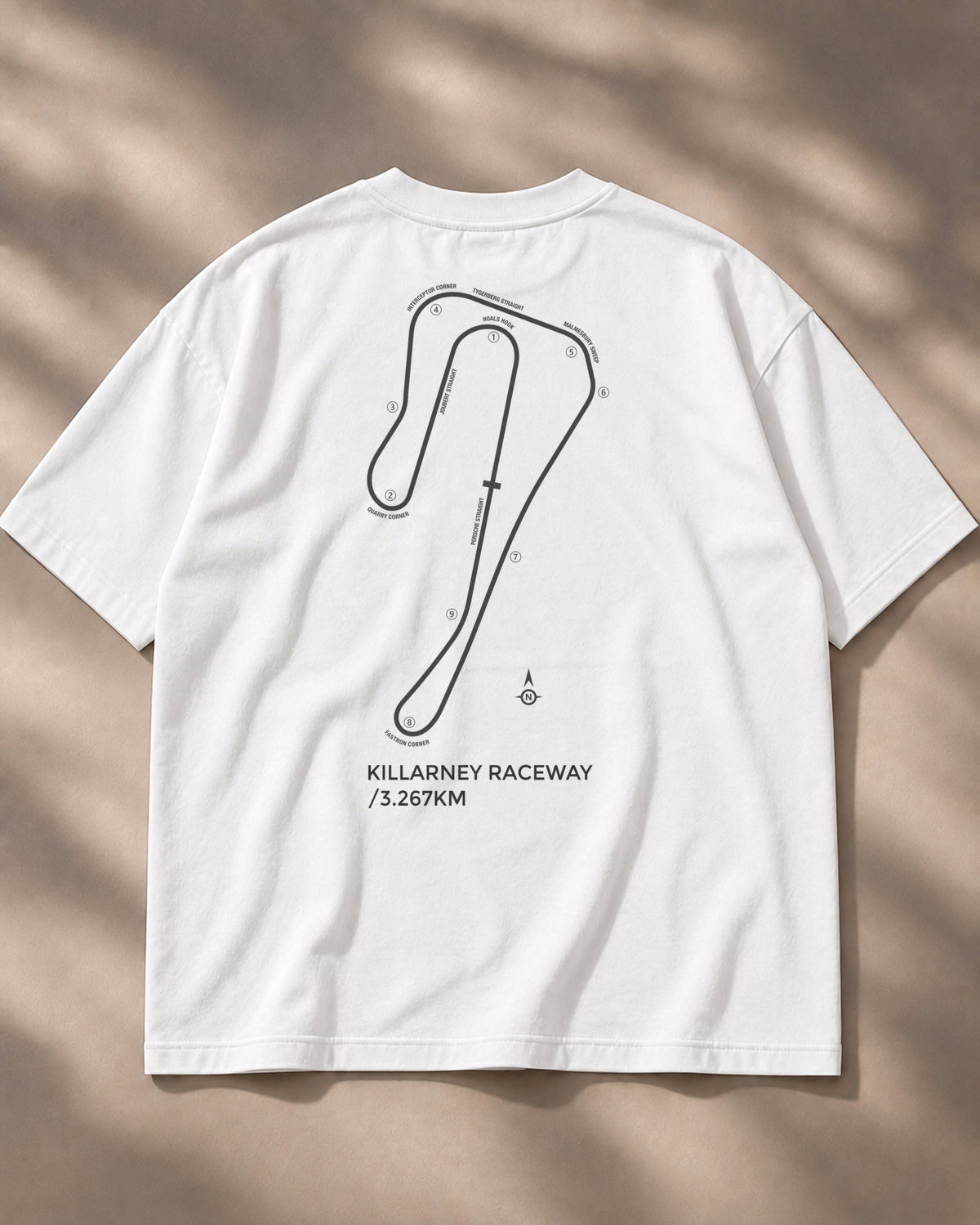 Circuit 001 Detailed tee in white, laid flat from the back: the Killarney Raceway map with every corner numbered and named, printed in black
