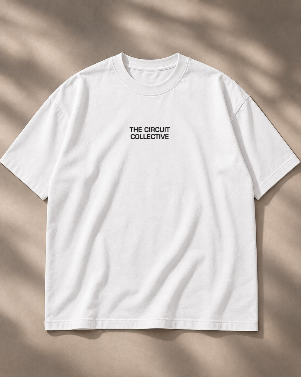 Circuit 001 Detailed tee in white, laid flat from the front: The Circuit Collective wordmark on the chest